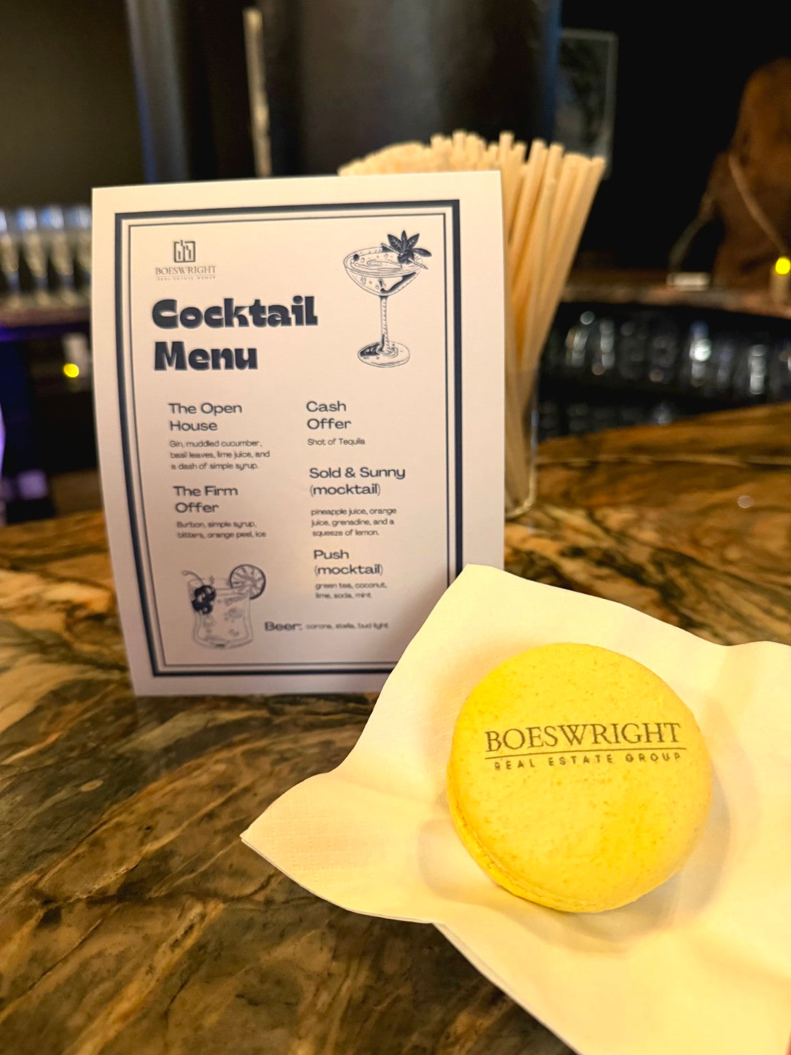 Custom cocktail menu sign styled on a bar with event details