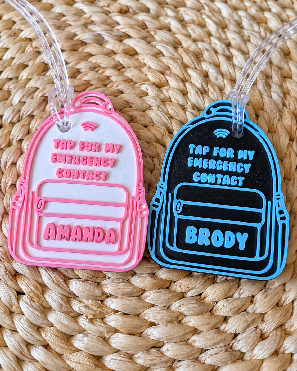 Illustrative personalized NFC emergency contact backpack tag examples: Amanda in pink and white, Brody in blue and black