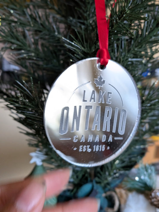 Lake Ontario Canada silver mirrored acrylic Christmas ornament with red ribbon hanging on a tree