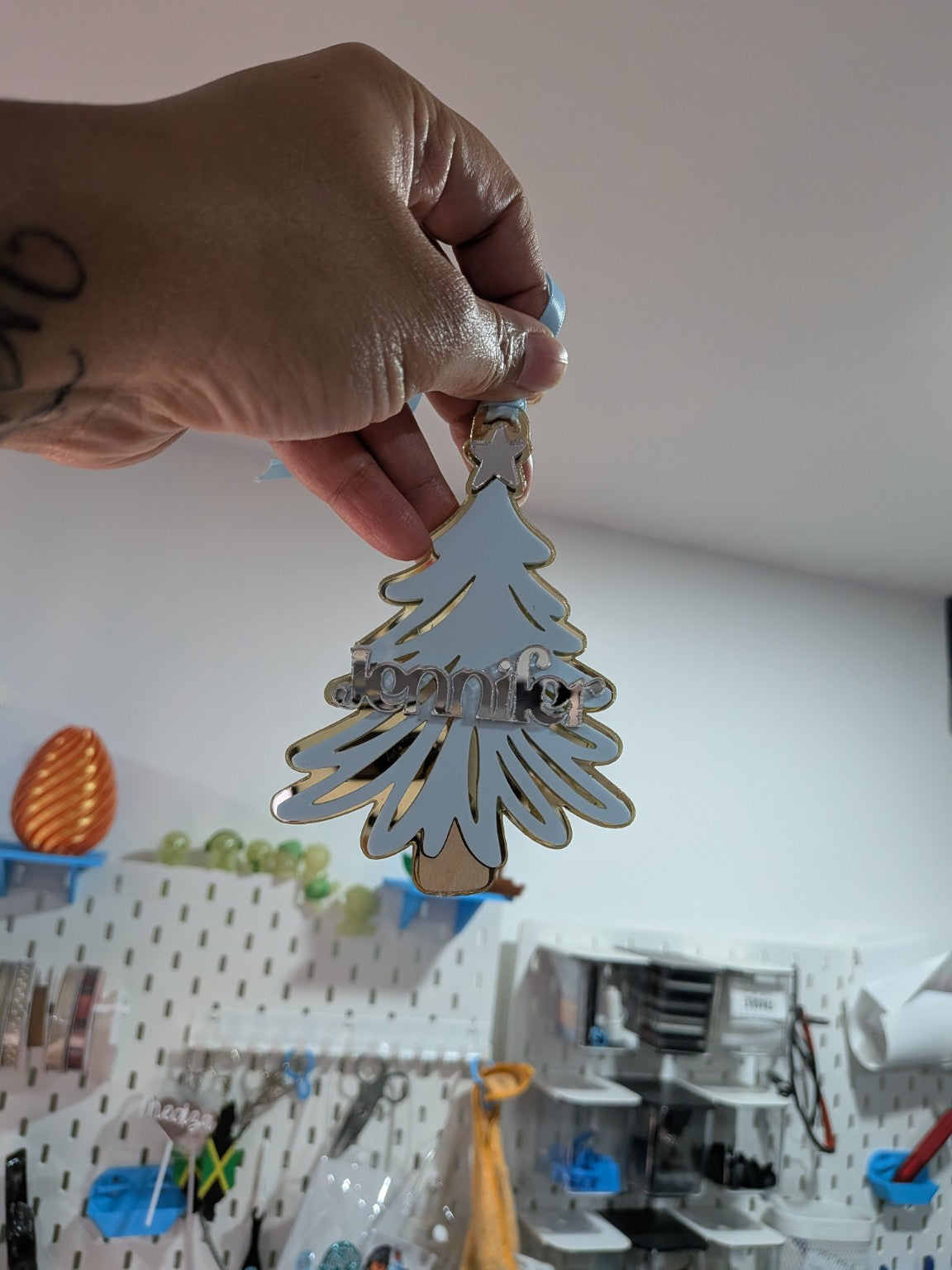 Personalized Christmas tree name ornament shown by hand