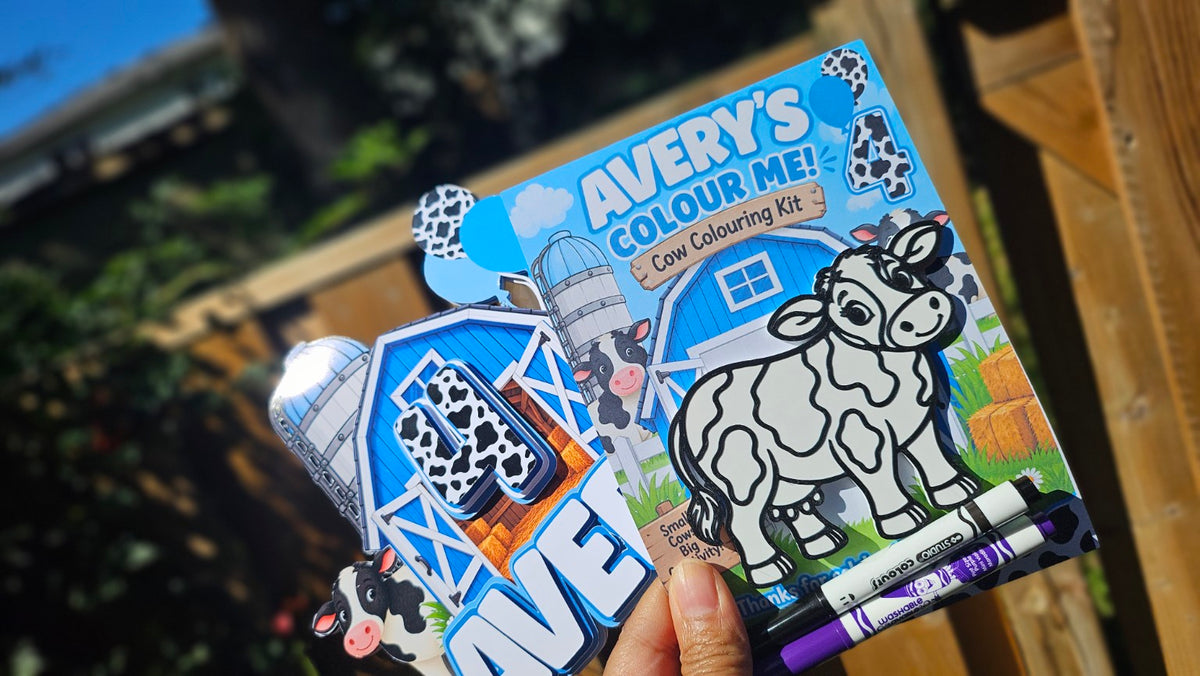Personalized cow colouring kit held outdoors showing custom name, age, cow and markers