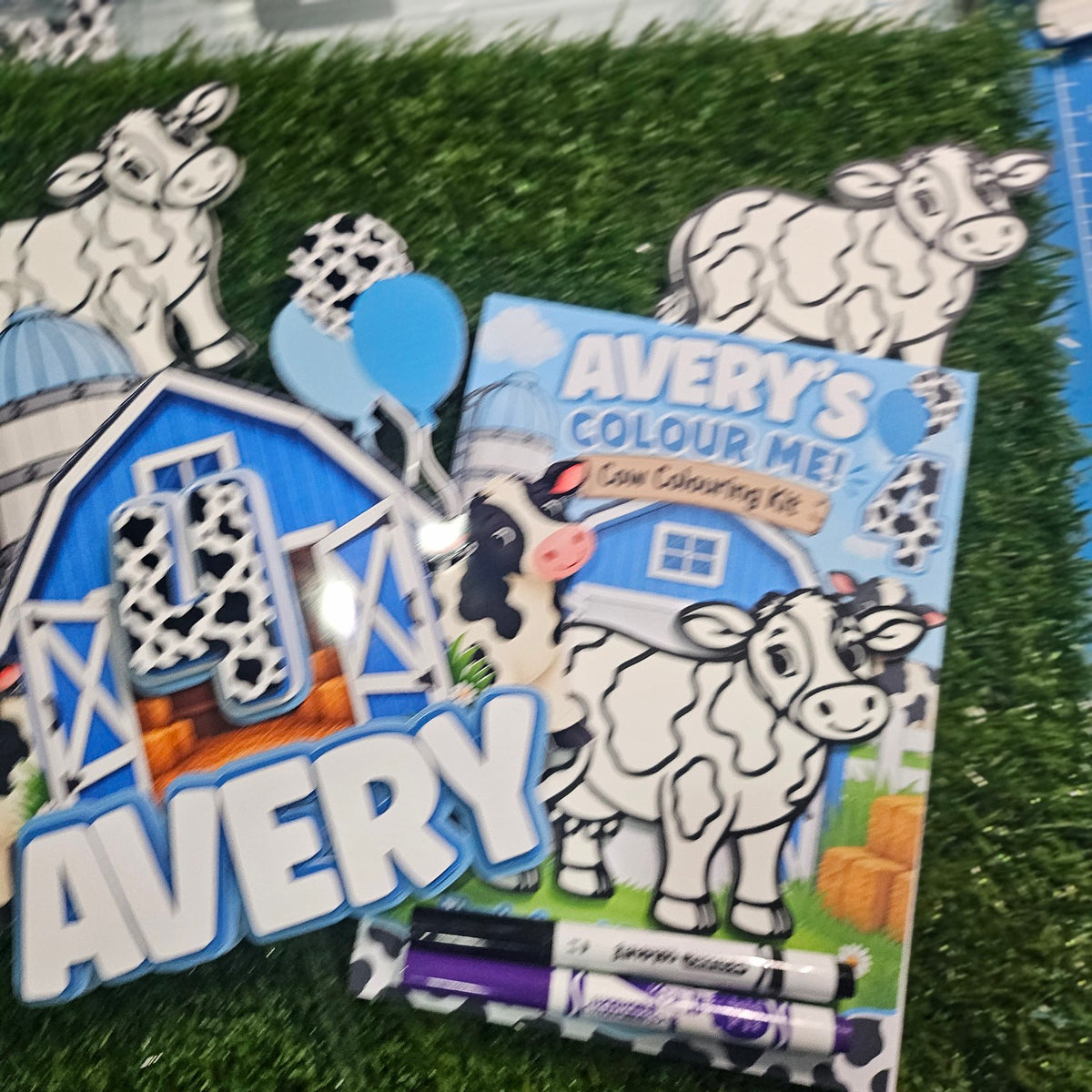 Personalized cow colouring kit shown with matching barn cake topper and cow decorations