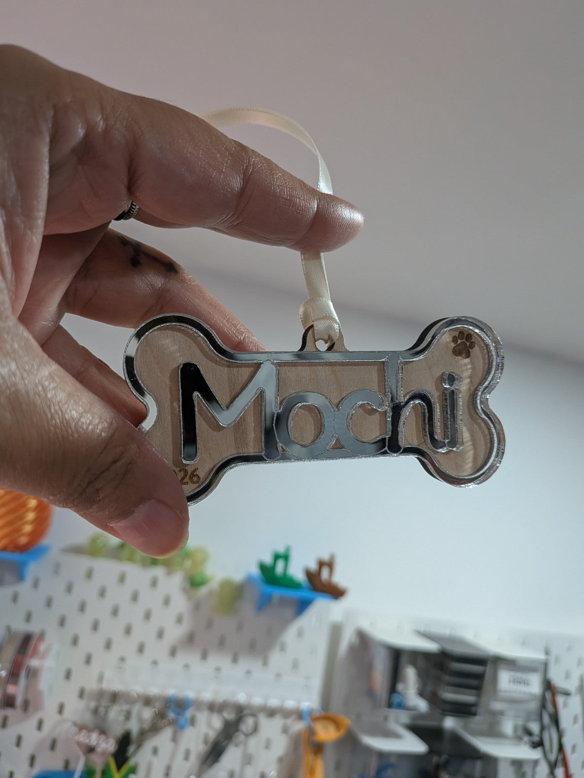 Personalized dog bone ornament shown by hand for scale