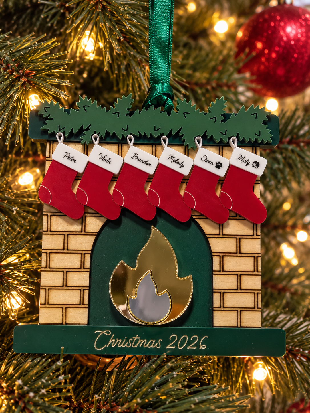 Personalized red and green fireplace family Christmas ornament hanging on a Christmas tree